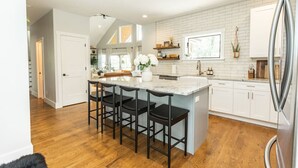 A spacious kitchen with a large island, white cabinetry, and a modern design. - Cozy Luxury Treehouse, 10 Min To Asheville, Mountain Views (Swannanoa)