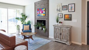 A living room with a fireplace, a sofa, a coffee table, and a cabinet.