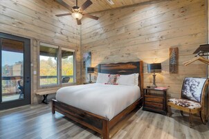 A wooden cabin bedroom with a bed, a chair, a nightstand, and a window.