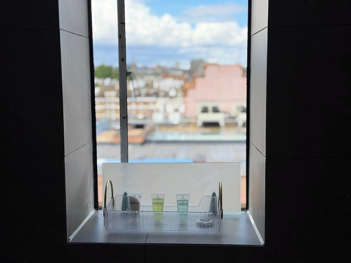 Ein Fenster mit Blick auf Gebäude und einen klaren Himmel.