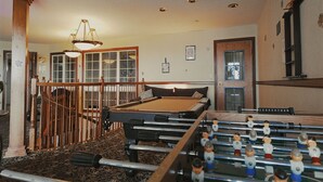 A room with a pool table, foosball table, and a staircase leading to another level. - Hotel suite with AC, WiFi, fitness room in welcoming Wilkes-Barre (Wilkes-Barre)