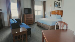 A hotel room with a bed, a TV, a sofa, a desk, and a chair. - Hotel suite with AC, WiFi, fitness room in welcoming Wilkes-Barre (Wilkes-Barre)