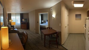 A hotel room with a dining area, a bed, a TV, a lamp, and a refrigerator. - Hotel suite with AC, WiFi, fitness room in welcoming Wilkes-Barre (Wilkes-Barre)