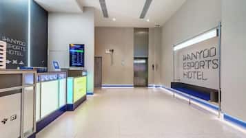 A reception area with a digital display, reception desk, and a wall sign for the WANYOO Esports Hotel.
