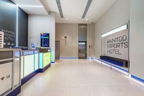 A reception area with a digital display, reception desk, and a wall sign for the WANYOO Esports Hotel. - Shengjia Theme Hotel (Guangzhou Dashi Metro Station) (Guangzhou)