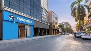 A street view with a blue building featuring a bear logo and Chinese characters. - Shengjia Theme Hotel (Guangzhou Dashi Metro Station) (Guangzhou)