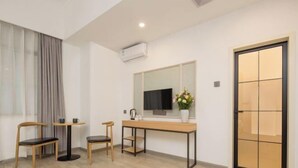 A modern room with a wooden desk, two chairs, a TV, and a large window with curtains. - Shengjia Theme Hotel (Guangzhou Dashi Metro Station) (Guangzhou)