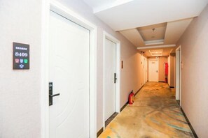 A hotel hallway with doors, a fire extinguisher, and a carpeted floor. - Shengjia Theme Hotel (Guangzhou Dashi Metro Station) (Guangzhou)