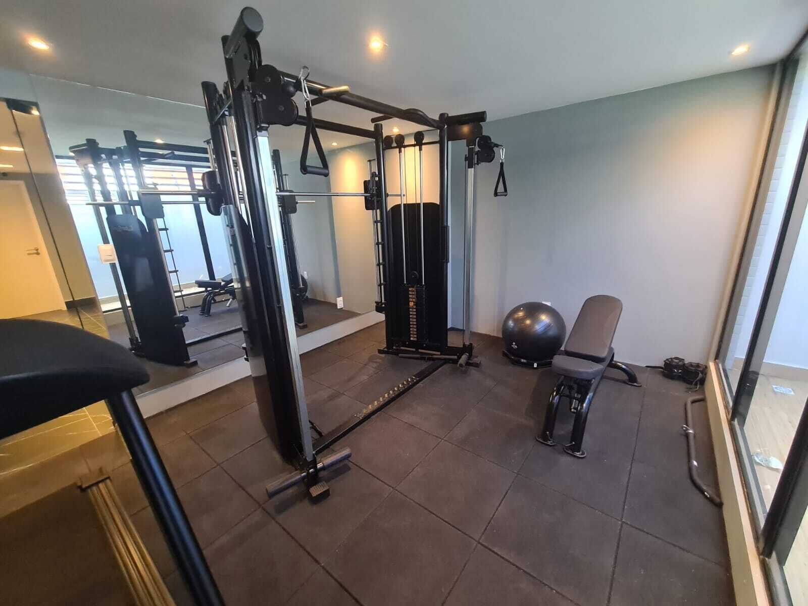 A gym with exercise equipment, a bench, and a chair.