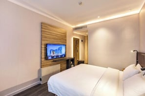A hotel room with a bed, a television mounted on the wall, and a wooden panel design on the wall. - HanTing Premium Hotel (Xiamen Botanical Garden Bailuzhou Road) (Xiamen)
