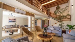 A spacious living area with a staircase, wicker chairs, a sofa, and a coffee table. - Beautiful luxury villa in the heart of San Pancho, ideal for families and friends. (San Francisco)