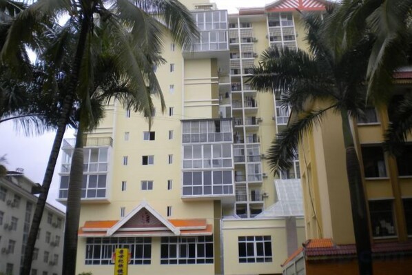 A multi-story building with balconies and a central entrance.