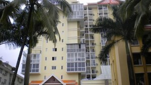A multi-story building with balconies, a flat roof, and a yellow facade. - Jingshiji Express Hotel (Jinghong)
