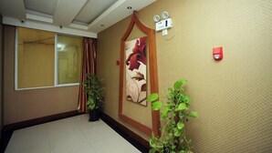 A hallway with a large window, a painting, and a wall-mounted light fixture. - Jingshiji Express Hotel (Jinghong)