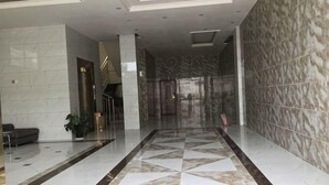 A spacious lobby with a marble floor, a glass door entrance, and a staircase leading to upper levels. - Zhongjiang Fengshang Hotel (Zhongjiang)