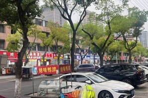 A street scene with parked cars and trees lining the sidewalk. - Daying Hotel (Ningbo)