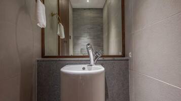 Une salle de bain avec un lavabo, un miroir et un porte-serviettes.