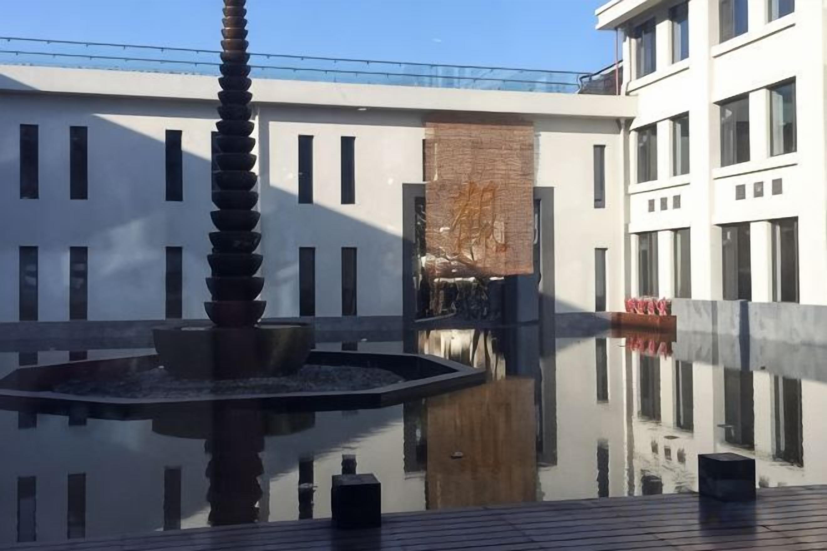 A courtyard with a water feature and a building facade.