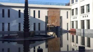 A courtyard with a water feature and a building facade.