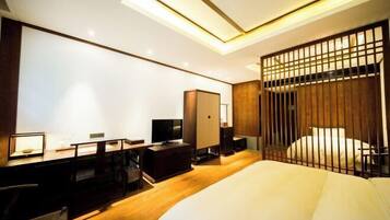 Une chambre d’hôtel moderne avec un bureau en bois, un lit et une télévision.