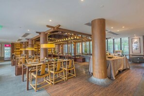 A spacious restaurant with wooden furniture and a high ceiling. - Ruyi Resort · International Cultural Center of Buddhism, Putuoshan (Zhoushan)