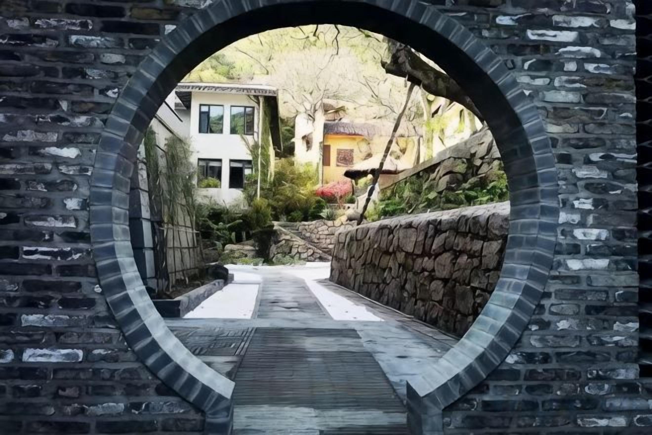 A brick archway leading to a pathway.