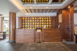 Una reception con finiture in legno, una parete di plafoniere circolari e un soffitto con travi a vista.