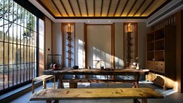 A traditional Japanese-style room with tatami flooring, a low wooden table, and a large window providing natural light.
