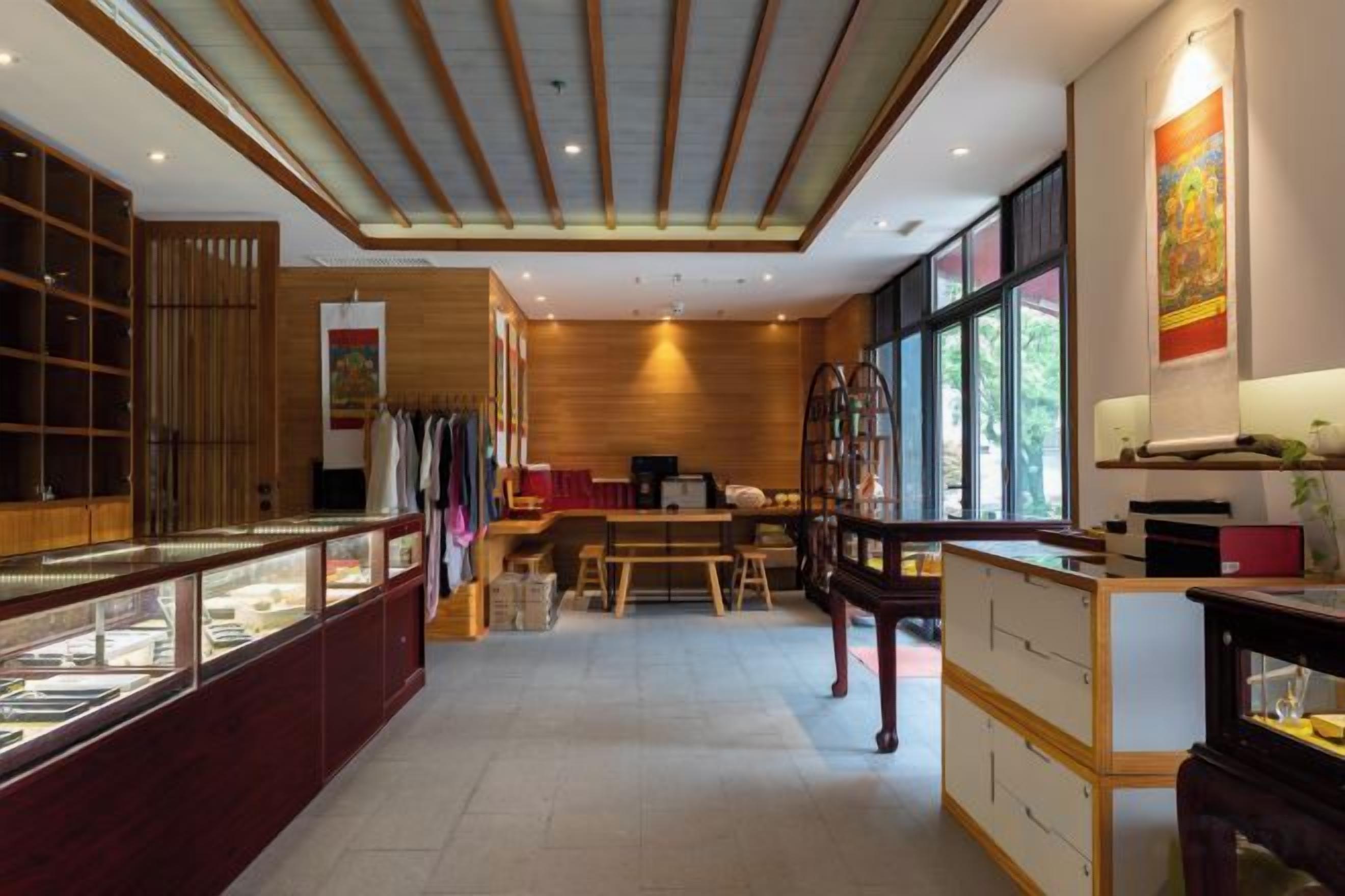 A traditional Japanese-style interior with a wooden ceiling, a display counter with glass cases, and a dining area with a low table and chairs.