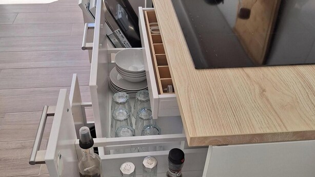 Une cuisine équipée d’une cuisinière intégrée, d’une machine à café et d’un plan de travail en bois.