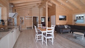 L’intérieur d’une cabane en bois comprend une cuisine, un coin repas et un espace de vie.