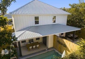 Une maison à deux étages dotée d’un patio couvert et d’une piscine.