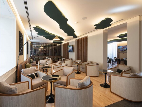 Ein moderner Lounge-Bereich mit Sofas, Sesseln und Tischen, komfortabel für Gäste eingerichtet.