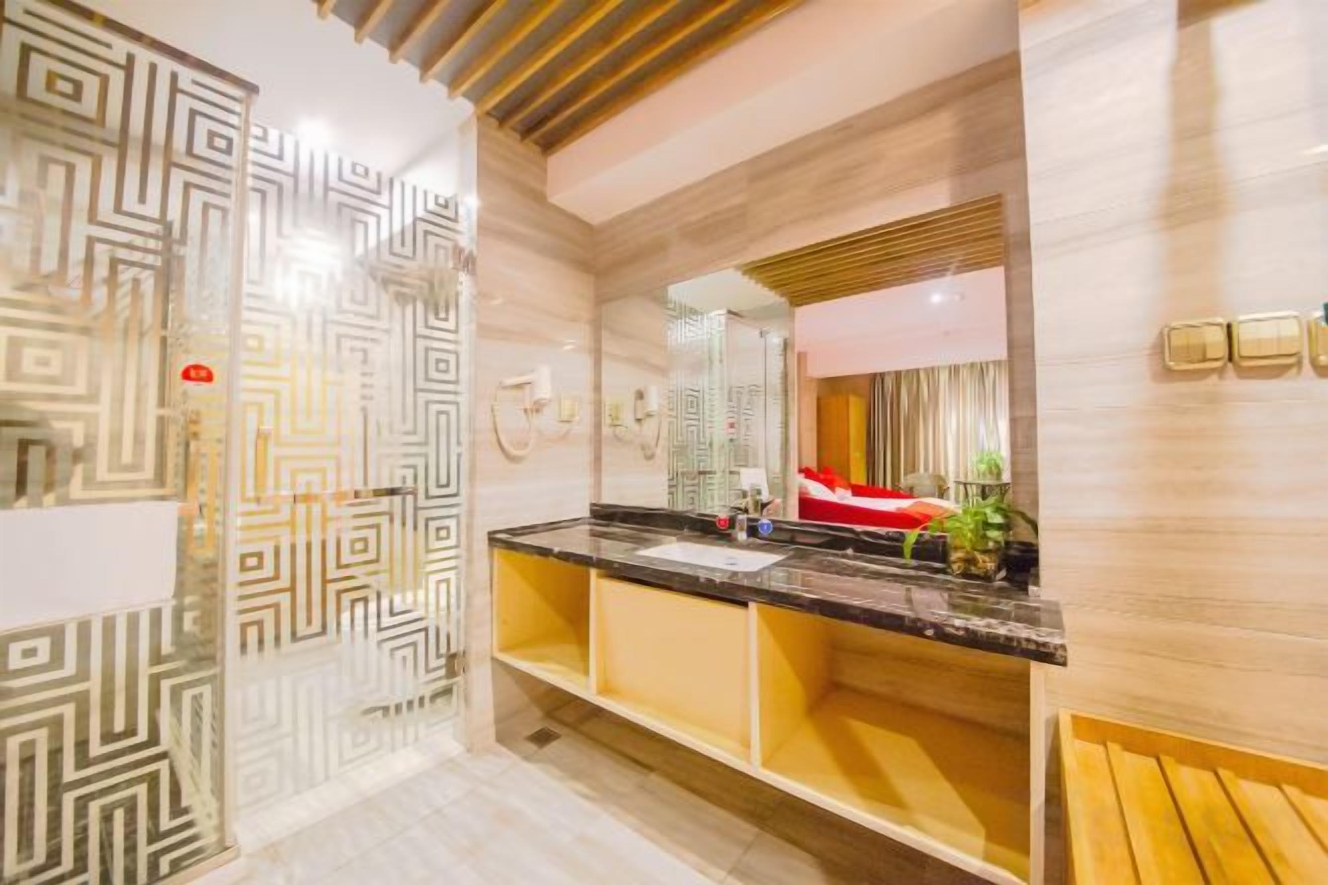 A modern bathroom with a marble vanity, a large mirror, and a red towel.