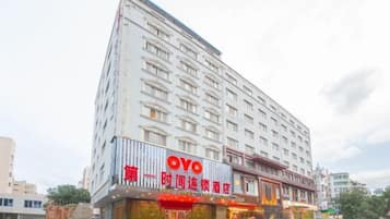 Un hotel de varios pisos con un letrero llamativo de 'OYO' y una entrada visible con un toldo rojo.