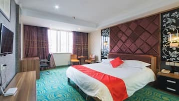 Habitación de hotel con una cama grande, un escritorio, una silla, un televisor y una ventana con cortinas.