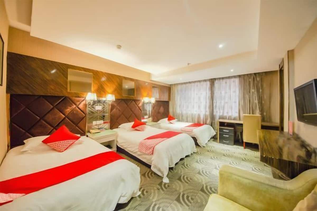 Ein Hotelzimmer mit zwei Betten, einem Fernseher, einem Schreibtisch und einem Stuhl.