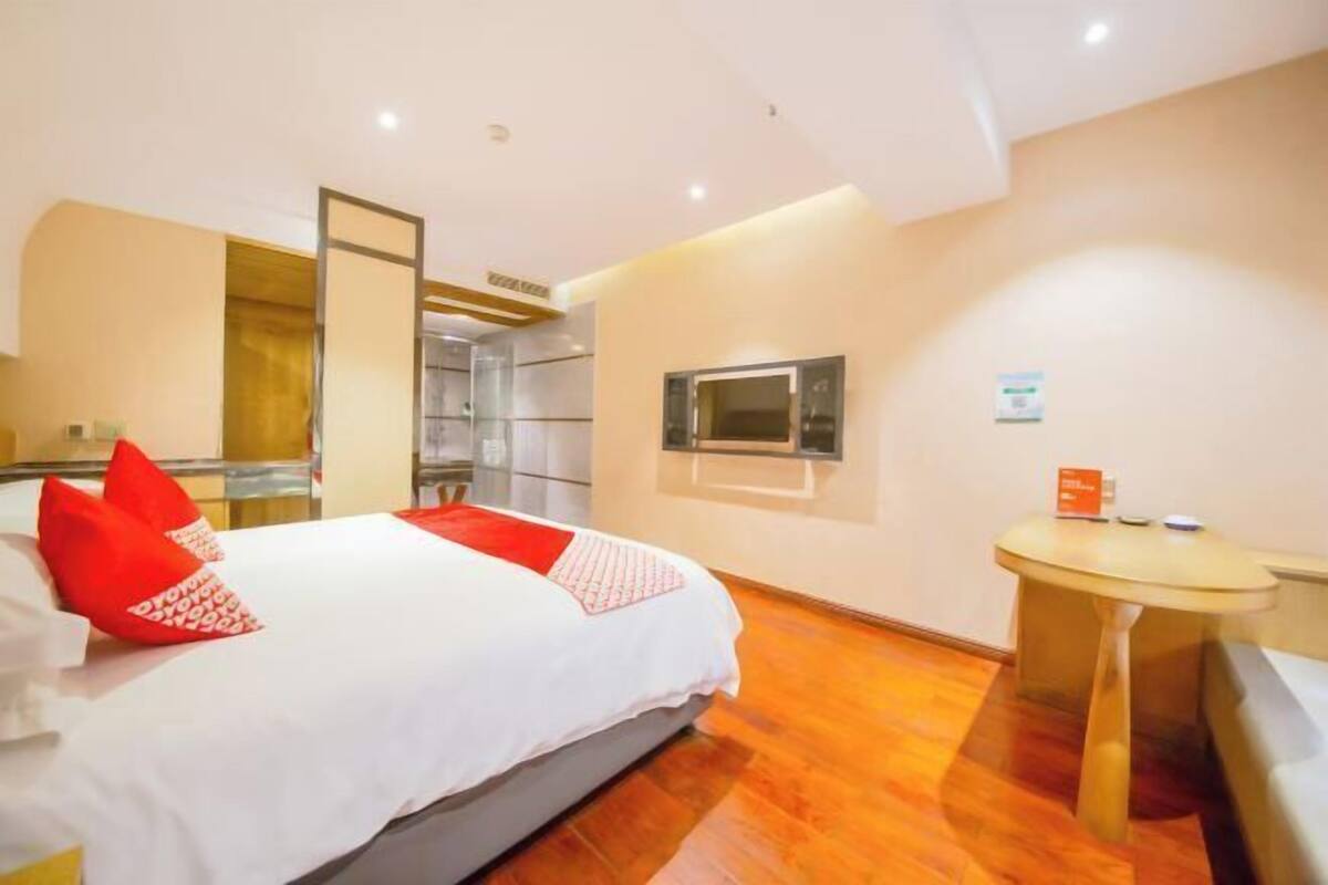 Ein Hotelzimmer mit einem Bett, einem kleinen Tisch und einem Fernseher.