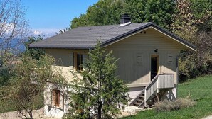 A single-story house with a sloped roof, a front porch, and a staircase leading to the entrance.