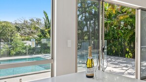 A room with a view of a swimming pool and tropical vegetation. - Belle Escapes Sea La Vie (Trinity Beach)