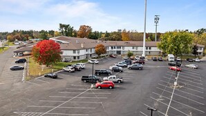 A parking lot with multiple cars and a building in the background.