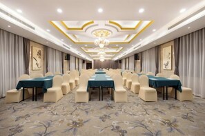 Una sala conferenze con un lungo tavolo, sedie e un lampadario.