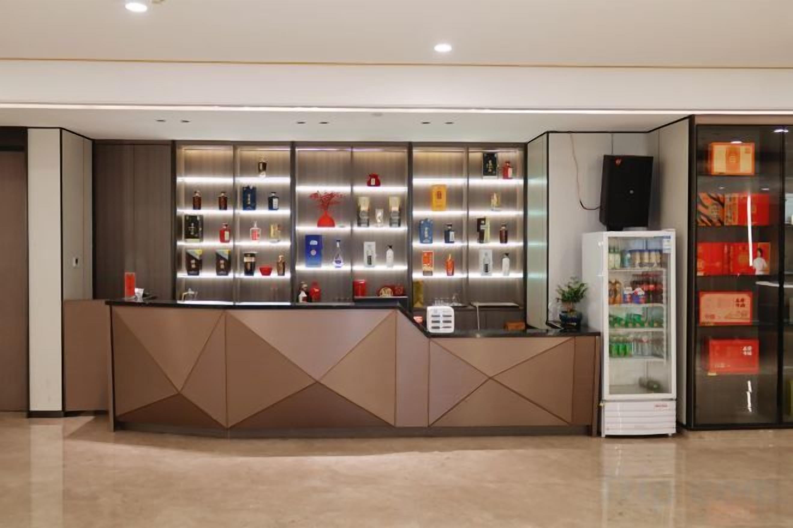 A reception area with a counter, a refrigerator, and a display of items.