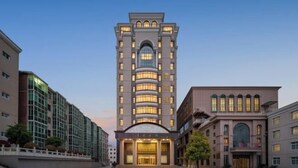 A multi-story hotel with a central entrance, large windows, and a symmetrical facade.