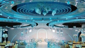 A luxurious venue with a central aisle, elegant floral arrangements, and a sophisticated ceiling design. - Qingping Hotel (Xinmi)