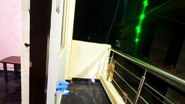 A corridor with a marble floor, a metal railing, and a green light strip. - BSSN Guest House (Gwalior)