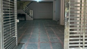 A hallway with a tiled floor, a ceiling fan, and a staircase in the background. - BSSN Guest House (Gwalior)