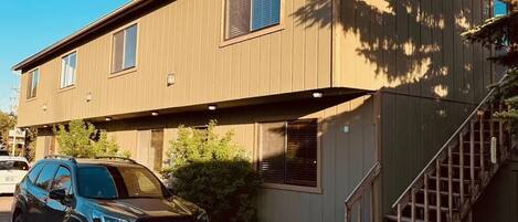 A two-story building with a car parked in front.