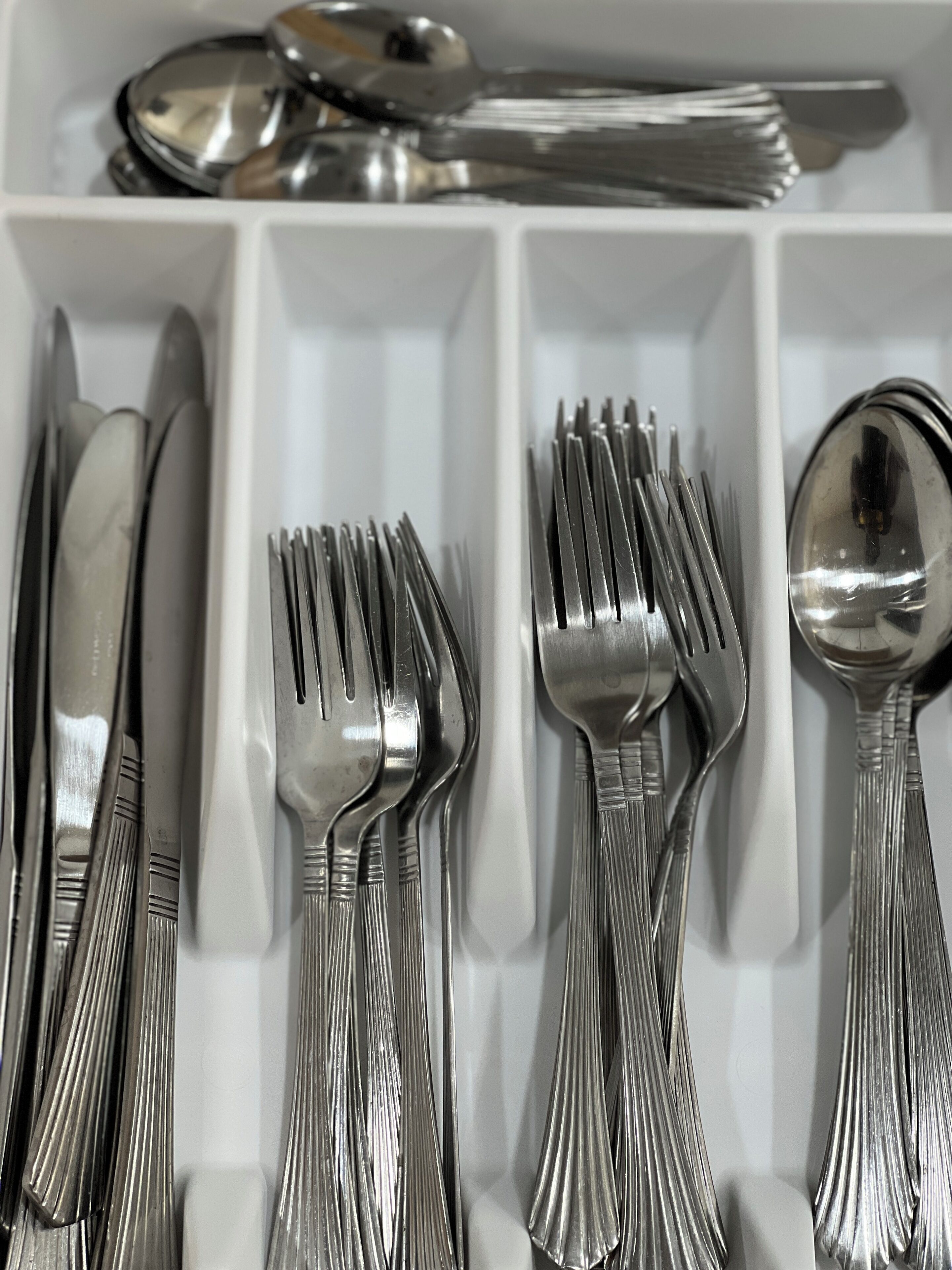 A drawer containing neatly organized silverware, including forks, knives, and spoons.
