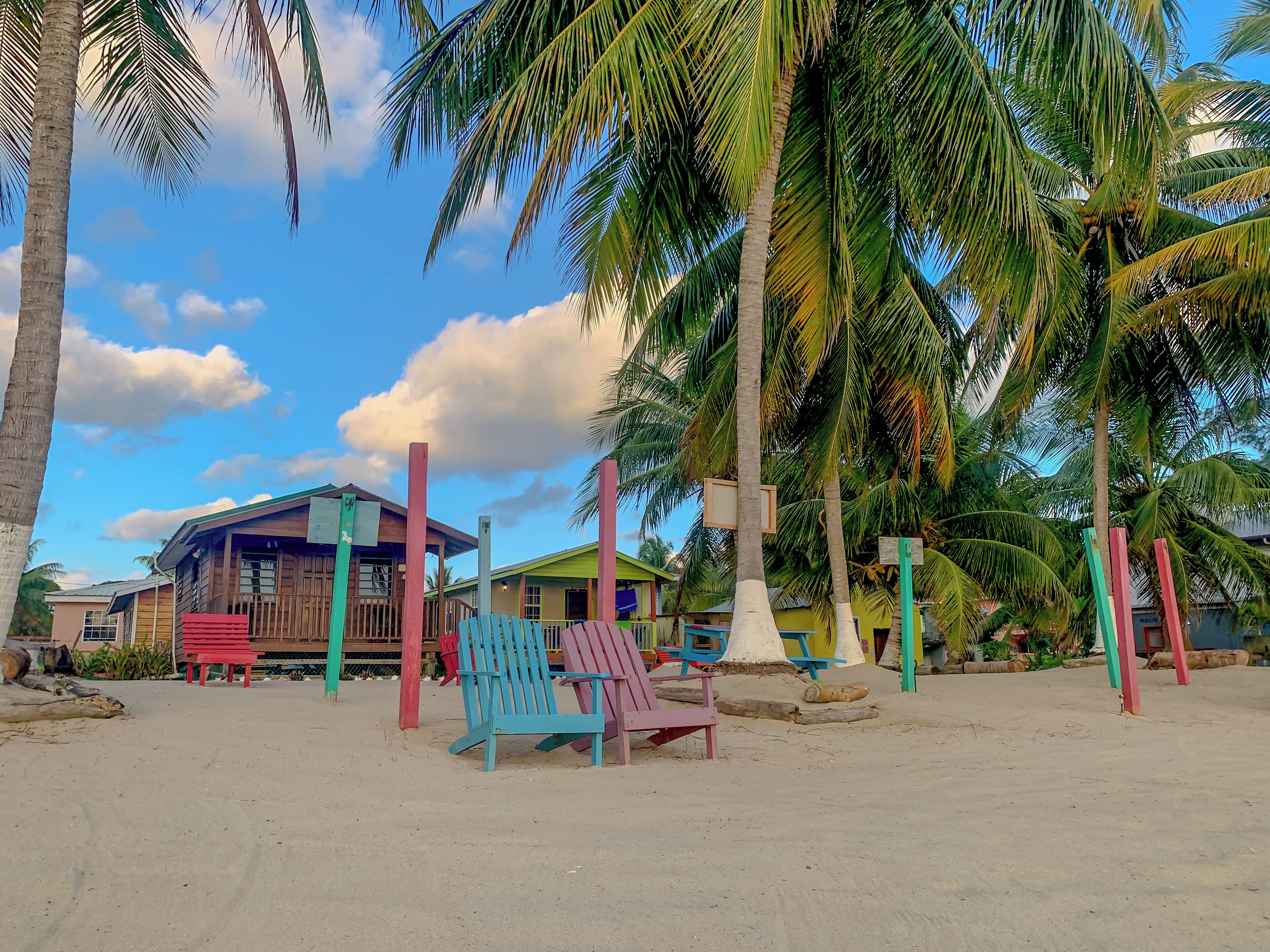 A beach area with colorful chairs and a wooden building with a sloped roof.